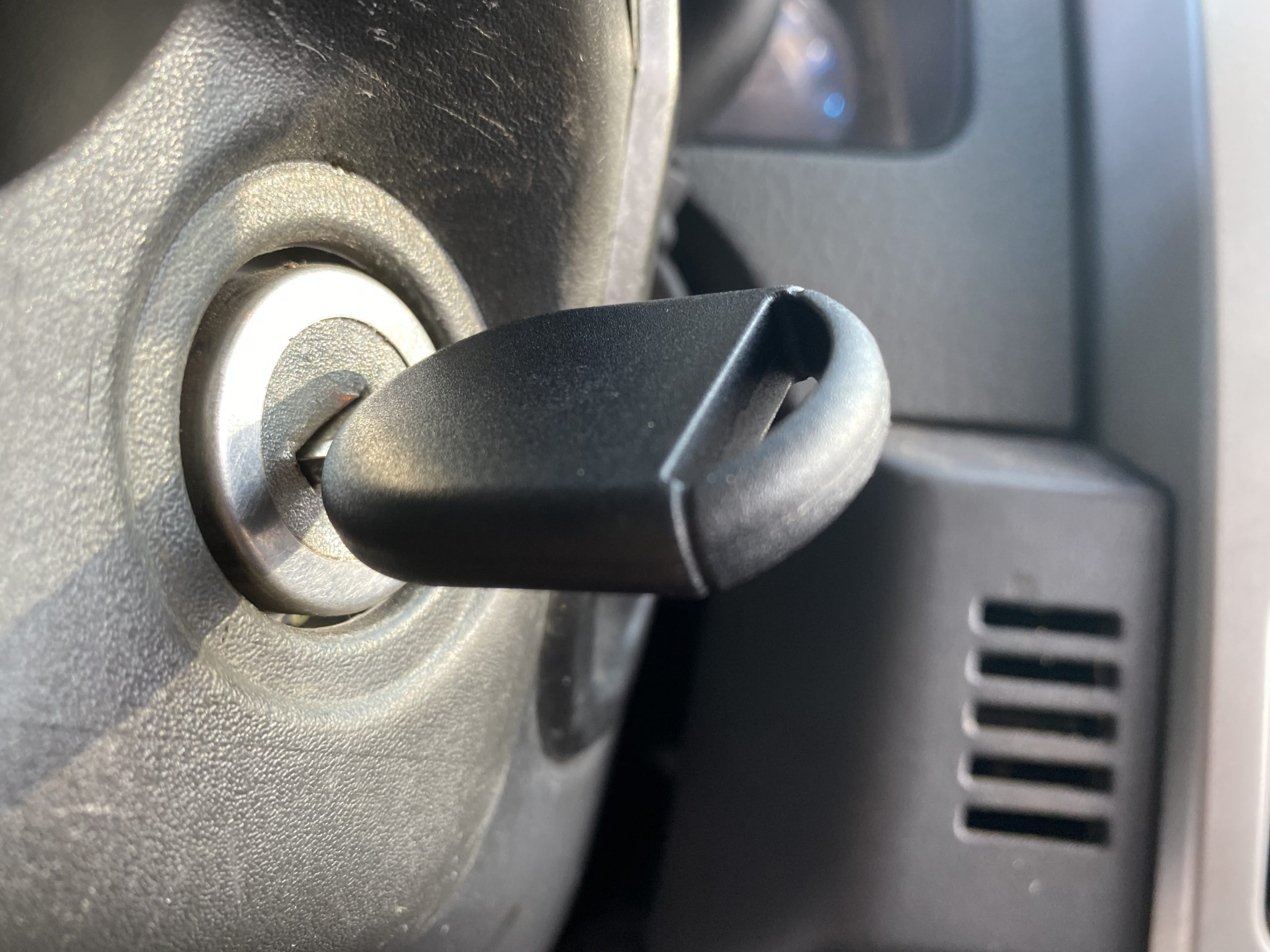 cyan colored car door lock getting picked open by a locksmith